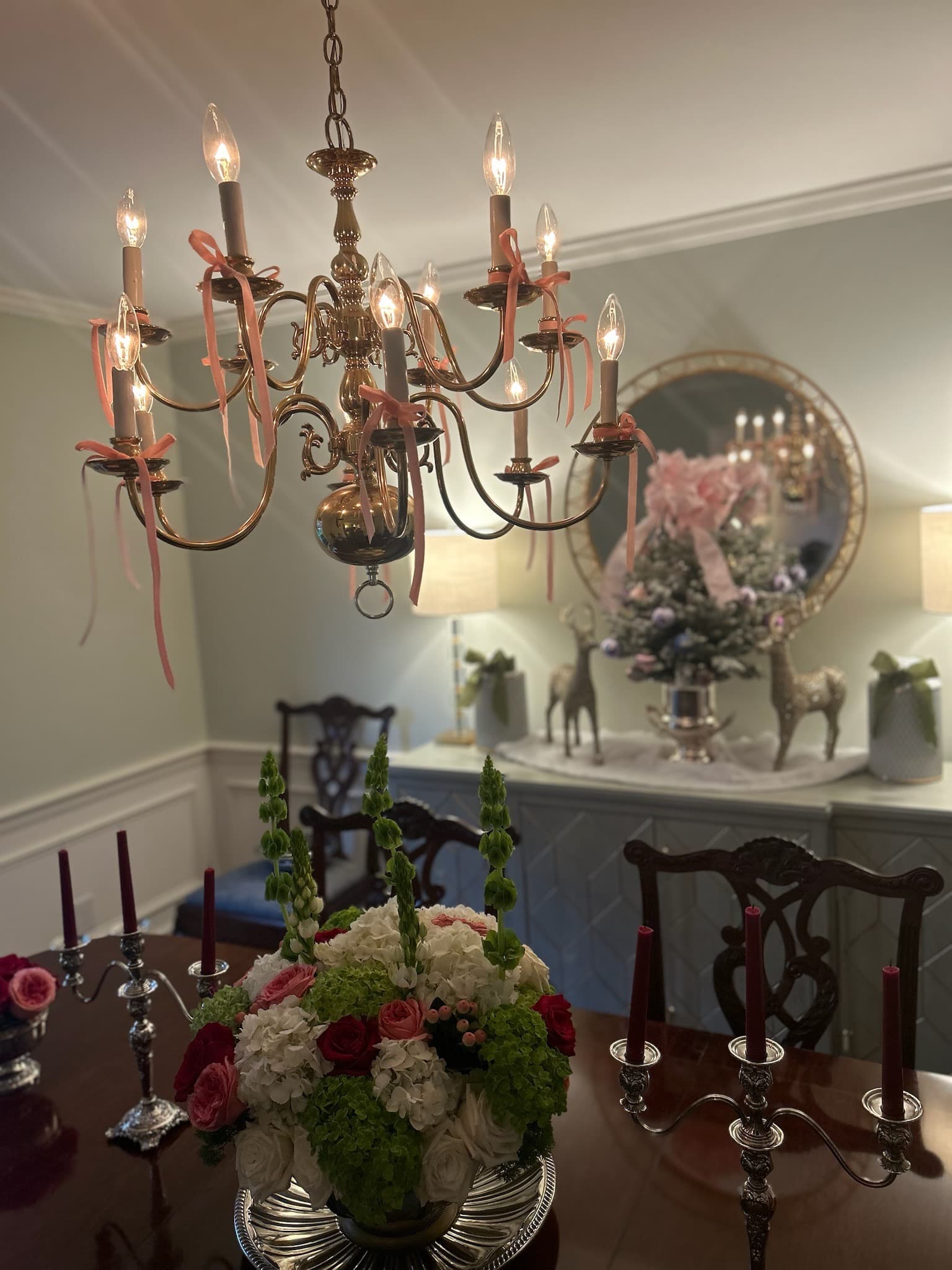 Holiday chandelier with pink ribbons and floral centerpiece