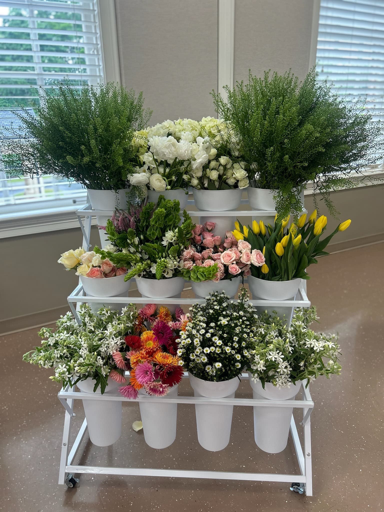 Tiered flower display with multiple seasonal bloom varieties
